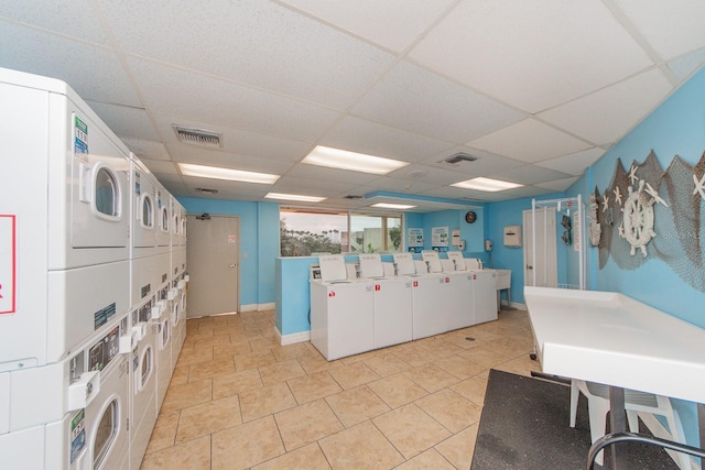 kitchen featuring washing machine and dryer, a drop ceiling, and stacked washing maching and dryer