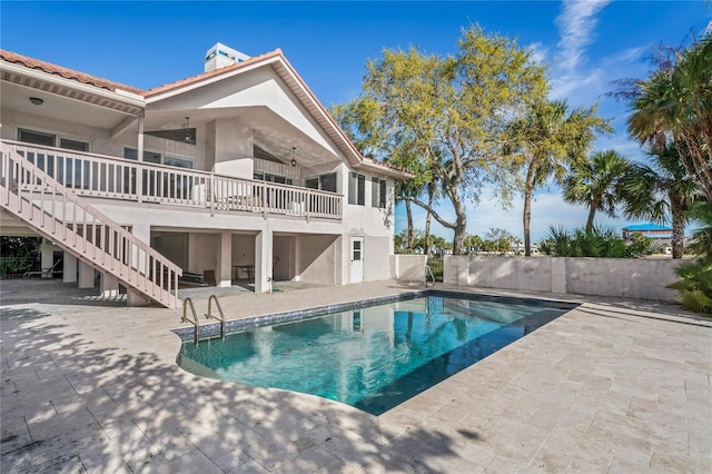 view of pool with a fenced in pool, a patio, stairway, fence, and a deck