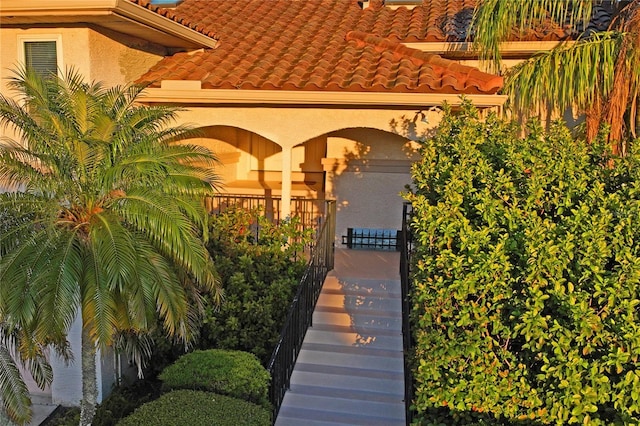 exterior space featuring a tiled roof and stucco siding