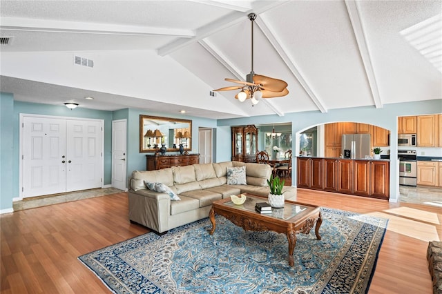 living area featuring a notable chandelier, high vaulted ceiling, visible vents, and light wood-style floors