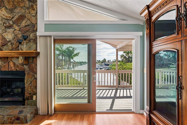 doorway featuring a textured ceiling, a fireplace, and wood finished floors