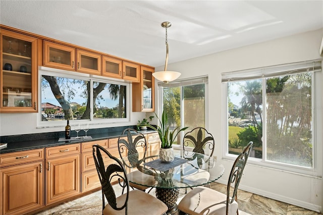 dining room featuring stone finish floor and baseboards