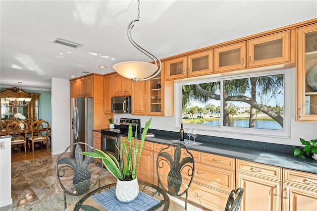 kitchen featuring stainless steel appliances, visible vents, hanging light fixtures, brown cabinets, and dark countertops