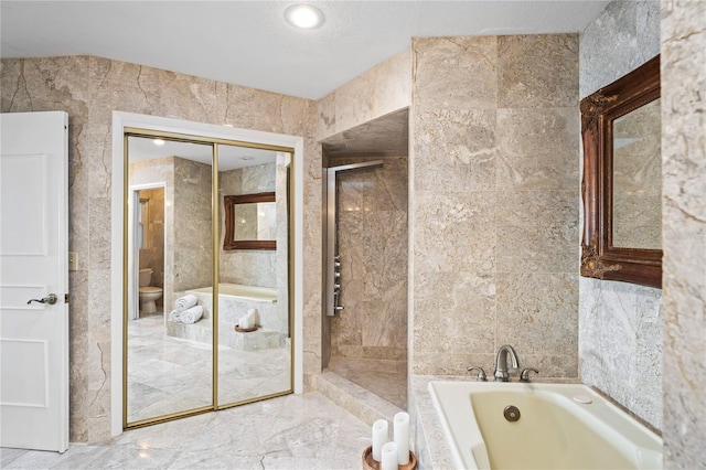 full bathroom with toilet, a shower stall, tile walls, and a bath