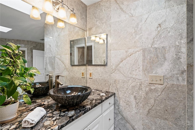 bathroom with vanity and tile walls