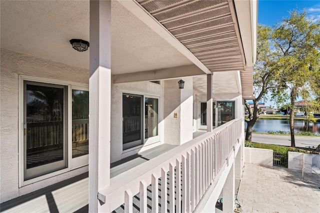 exterior space with a water view and stucco siding