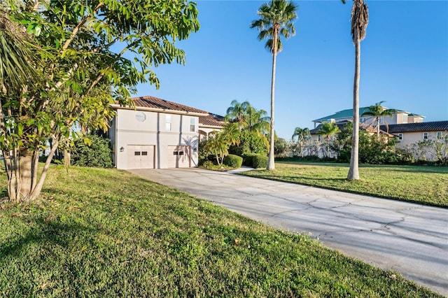 mediterranean / spanish house featuring a garage, concrete driveway, a tiled roof, stucco siding, and a front lawn