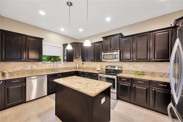 kitchen featuring a center island, stainless steel appliances, hanging light fixtures, backsplash, and a sink