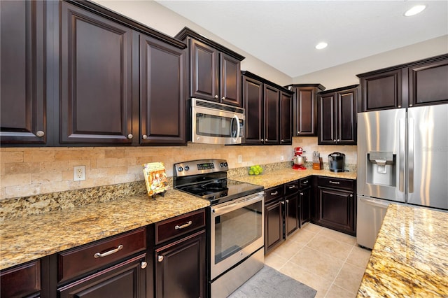 kitchen with light stone counters, stainless steel appliances, decorative backsplash, and light tile patterned flooring