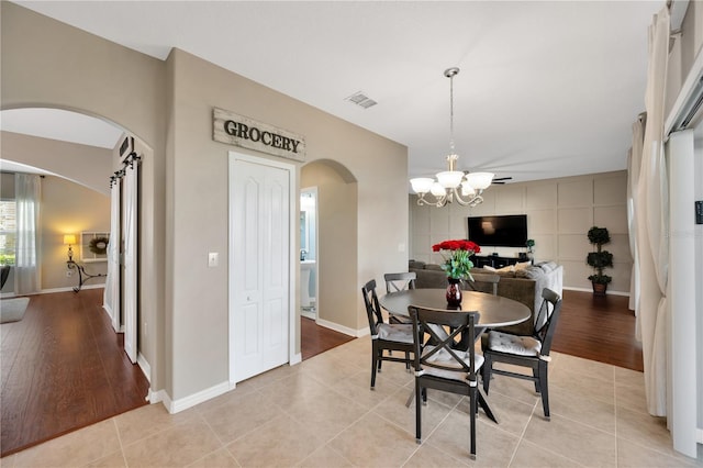 dining room featuring visible vents, arched walkways, baseboards, a chandelier, and light tile patterned flooring