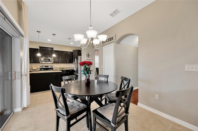 dining space featuring arched walkways, visible vents, baseboards, and light tile patterned floors