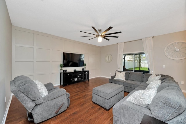 living room with baseboards, a ceiling fan, and dark wood-style flooring