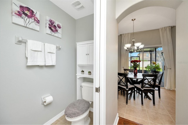 bathroom with baseboards, visible vents, toilet, tile patterned floors, and an inviting chandelier