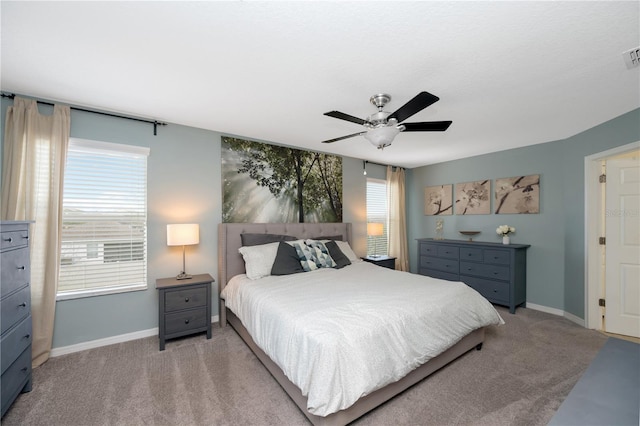 carpeted bedroom featuring visible vents, a ceiling fan, and baseboards