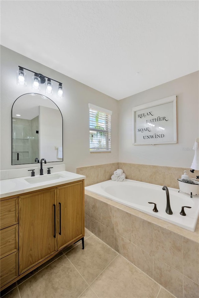 full bath with a garden tub, walk in shower, tile patterned flooring, and vanity