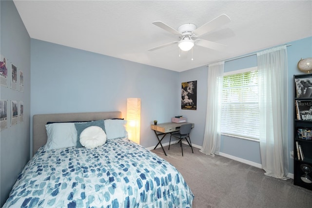 carpeted bedroom with ceiling fan and baseboards