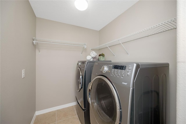 washroom with laundry area, baseboards, separate washer and dryer, and light tile patterned flooring