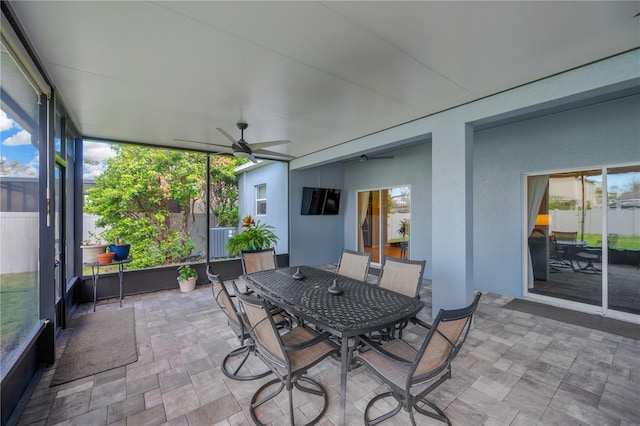 unfurnished sunroom featuring ceiling fan