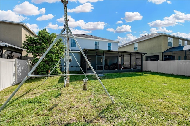 rear view of house featuring a sunroom, a fenced backyard, a lawn, and stucco siding