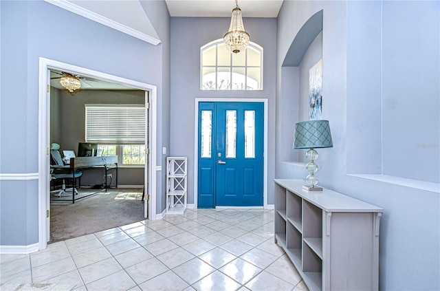 entrance foyer featuring light tile patterned floors, an inviting chandelier, baseboards, and light colored carpet