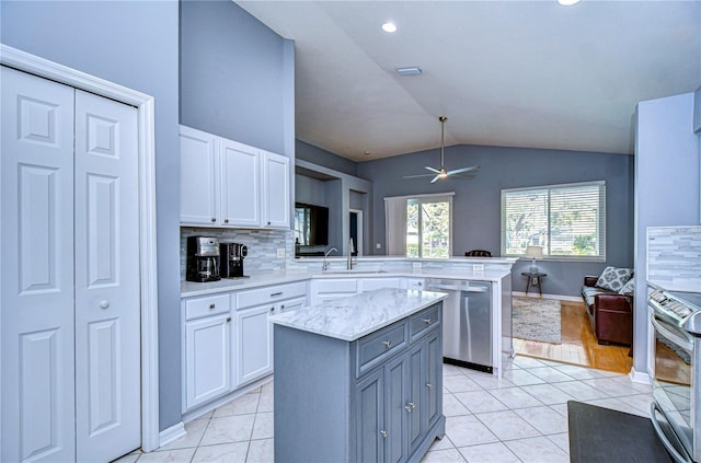 kitchen with a peninsula, light tile patterned floors, stainless steel appliances, and a sink