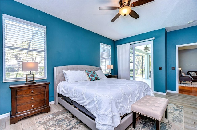 bedroom with access to exterior, a ceiling fan, baseboards, and wood finished floors