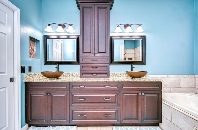 full bath with double vanity, a sink, and a bath