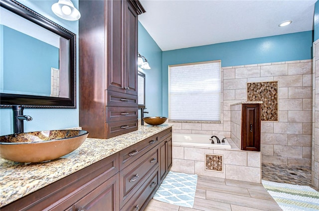 full bathroom featuring double vanity, a sink, and a bath