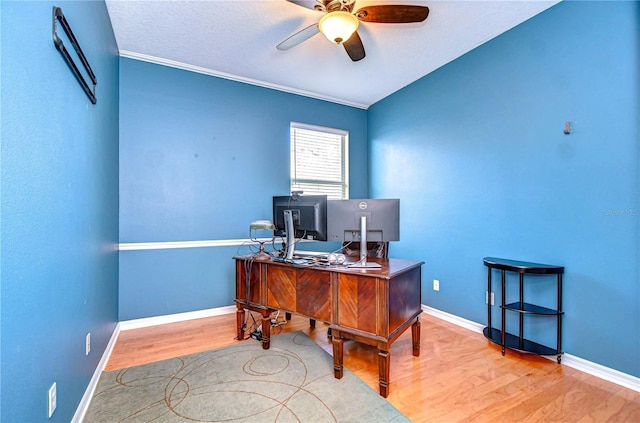 office area featuring ornamental molding, ceiling fan, baseboards, and wood finished floors