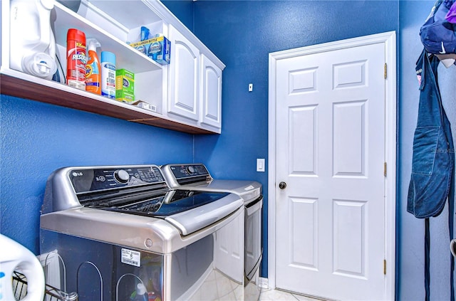 laundry room with light tile patterned floors, separate washer and dryer, and cabinet space