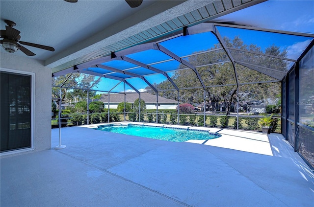 outdoor pool with a lanai, a patio area, and ceiling fan