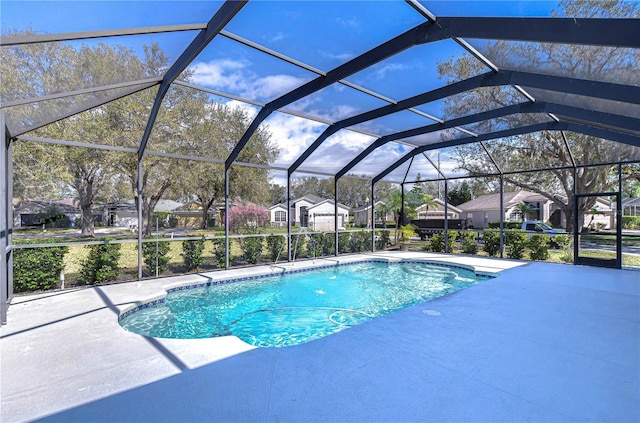 pool featuring a residential view, glass enclosure, and a patio