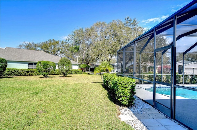 view of yard featuring glass enclosure, a patio, and an outdoor pool