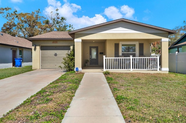 view of front of home featuring a porch, an attached garage, concrete driveway, stucco siding, and a front yard