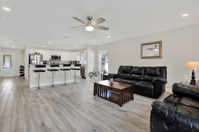 living room with light wood finished floors, baseboards, a ceiling fan, and recessed lighting