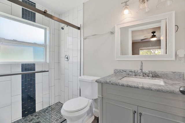 bathroom with plenty of natural light, a tile shower, toilet, and vanity