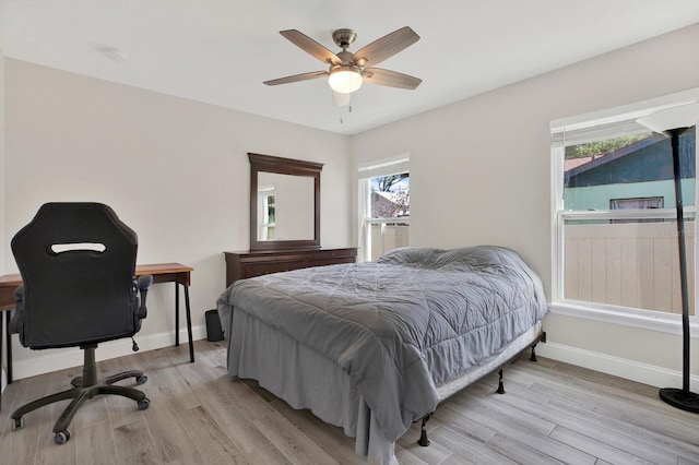 bedroom with baseboards, ceiling fan, and light wood-style floors