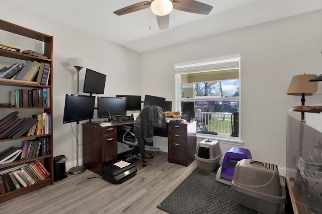 home office featuring light wood-style floors, baseboards, and a ceiling fan