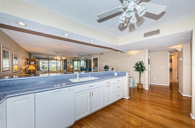 kitchen featuring visible vents, a sink, a textured ceiling, dishwasher, and light wood-type flooring