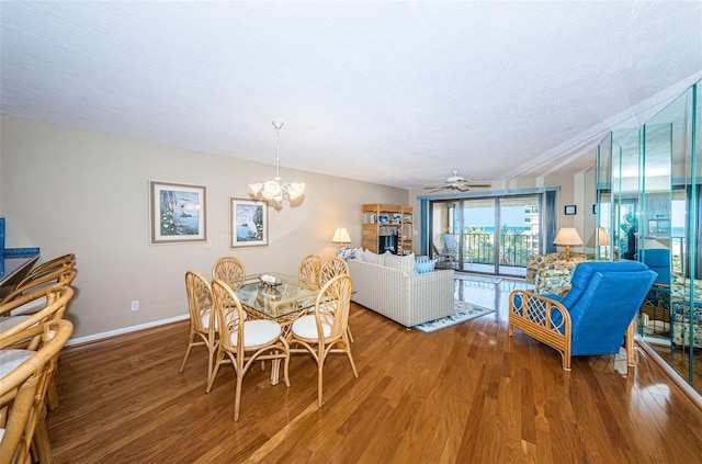 dining space with a textured ceiling, baseboards, and wood finished floors