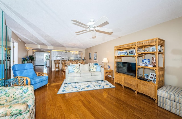 living room featuring ceiling fan with notable chandelier, a textured ceiling, and wood finished floors