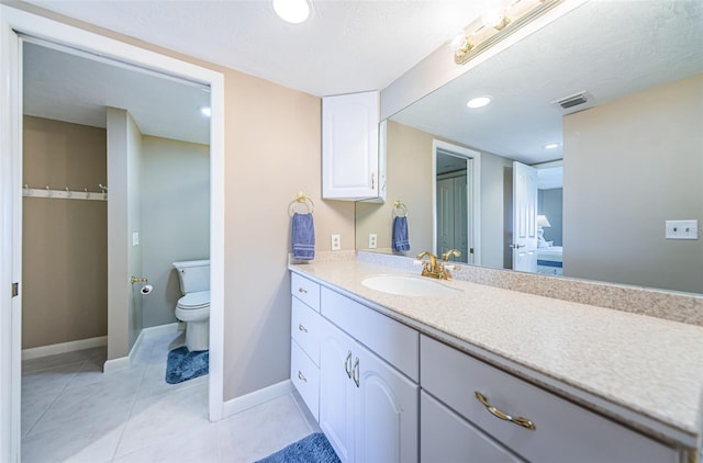 bathroom with tile patterned floors, visible vents, toilet, baseboards, and vanity