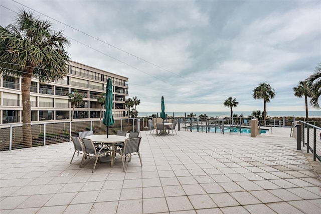 view of patio with a community pool and a water view