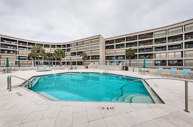 pool with a patio area and fence