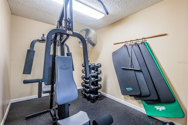 workout area with a textured ceiling and baseboards