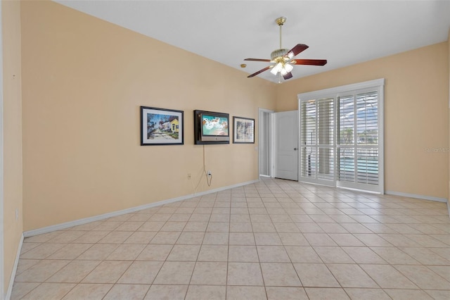 spare room with light tile patterned flooring, a ceiling fan, and baseboards