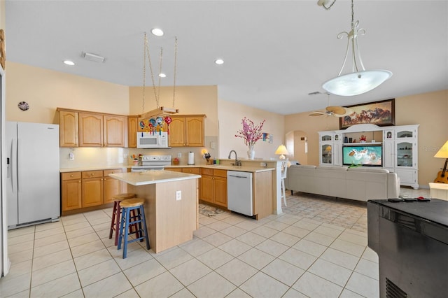 kitchen featuring arched walkways, light countertops, white appliances, and open floor plan