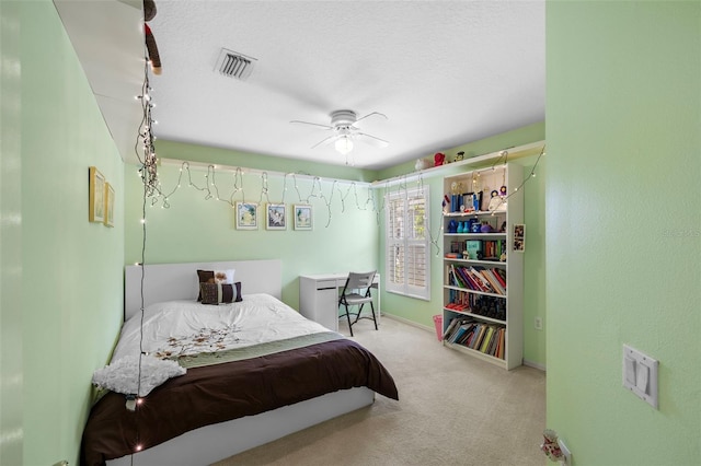 carpeted bedroom with ceiling fan, a textured ceiling, visible vents, and baseboards