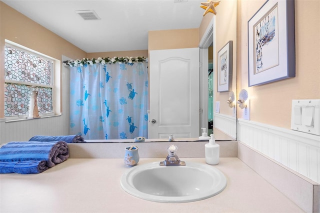 bathroom featuring wainscoting, vanity, visible vents, and a shower with curtain