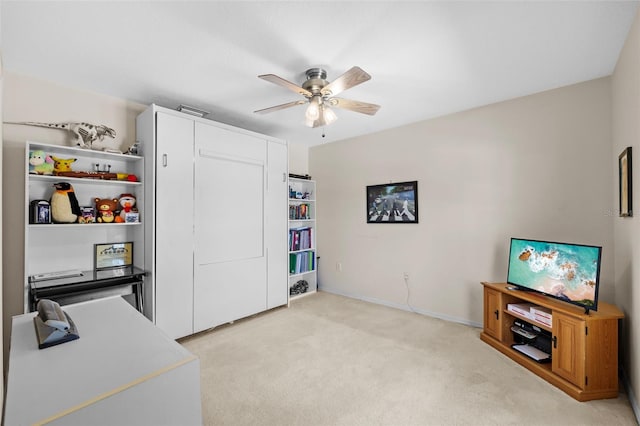 office area with baseboards, a ceiling fan, and light colored carpet